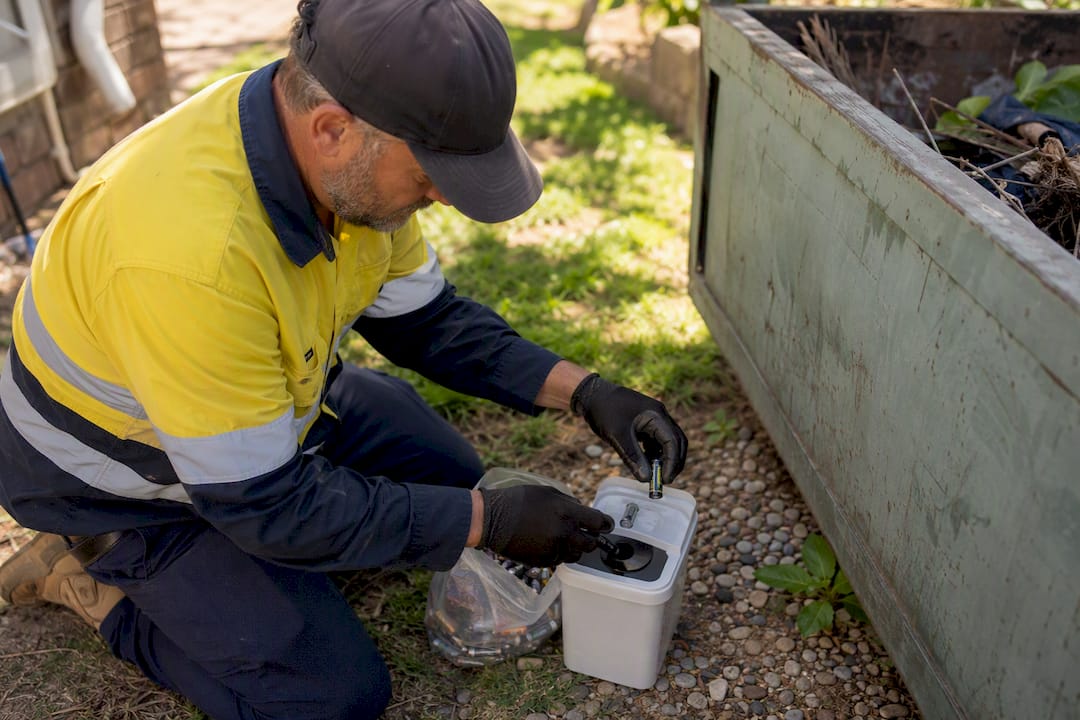 Hands removing batteries from skip waste